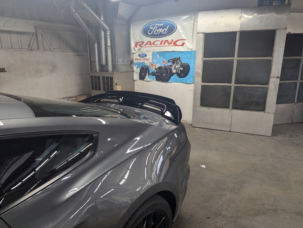 Ford Performance 2015-23 Mustang rear spoiler with gurney flap, showcasing aerodynamic design and sleek black finish.